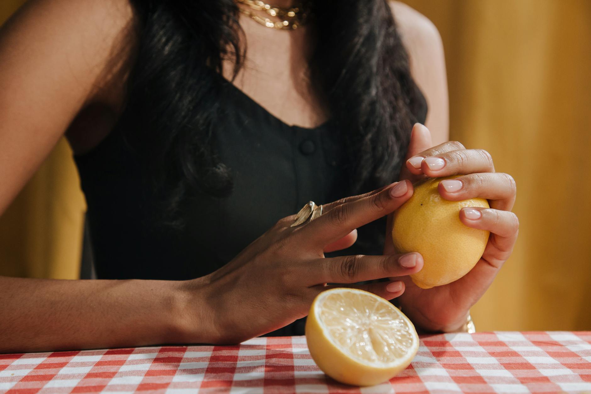 Hands holding a sleek blue lemon vibrator against a purple background