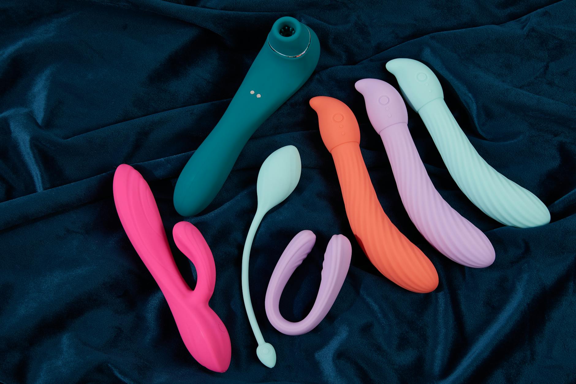 Young couple standing together indoors, holding a blue vibrator, symbolizing modern intimacy