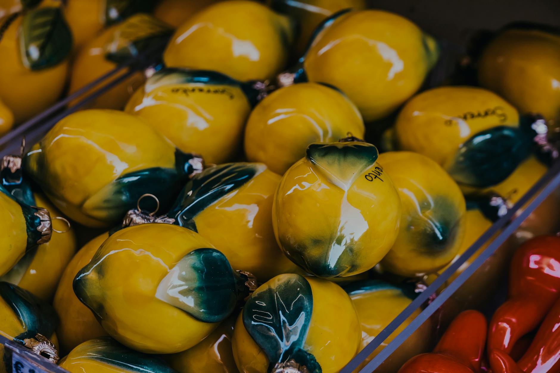 Vibrant yellow ceramic lemons artfully displayed in market setting, capturing artistic craftsmanship.